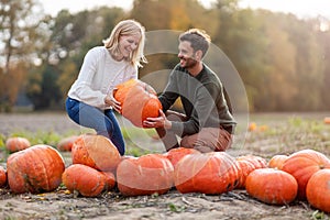 Young couple in pumpkin patch field