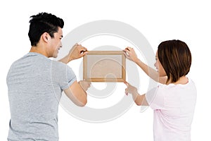 Young couple putting up picture frame