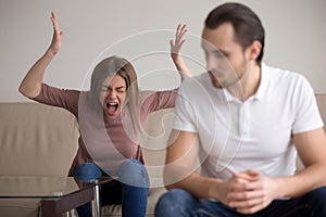 Young couple quarrelling, hysterical wife screaming at husband,