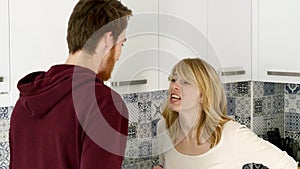 Young Couple Quarrels in the Kitchen. Man and Woman Scream in Frustration and Angrily Gesticulate