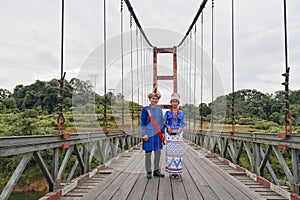 young couple of Rawang people in traditional Rawang dress at Kaungmulone Bridge across Mali Kha River in Putao, Kachin state.