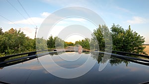 Young couple reaching hands out car sunroof during trip. Pair riding on car together and enjoying romantic moment