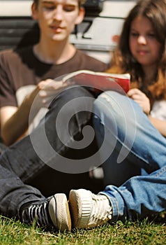 Young couple read the guidebook sitting near car