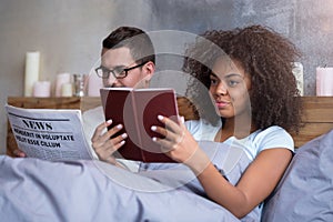 Young couple reading in bed together