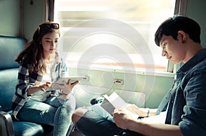 Young couple reading book and using tablet