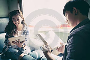 Young couple reading book and using tablet