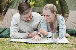 Young couple reading map in tent