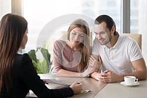 Young couple in real estate agency office meeting with agent