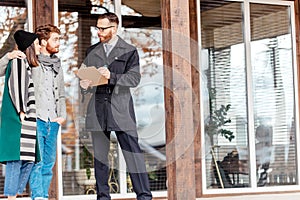Young couple with real estate agent near house, purchase or rent concept