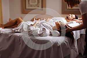 Young couple receiving head massage at beauty spa