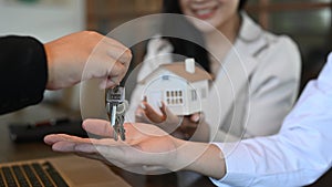 Young couple receiving keys from real estate agent. New house, insurance and real estate concept.