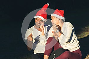 Young couple red hats singing Christmas carols