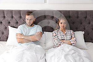 Young couple with relationship problems in bed