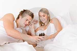 Young couple relax in bed listen to music