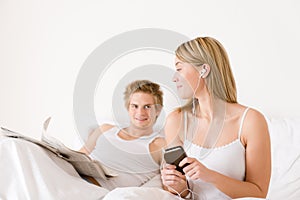 Young couple relax in bed listen to music