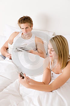 Young couple relax in bed listen to music