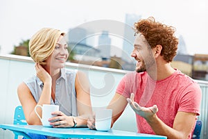 Young Couple Relaxing With Coffee On Roof Terrace