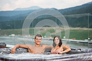 Giovane rilassante contento caldo vasca da bagno bolla bagno al di fuori sul vacanza 