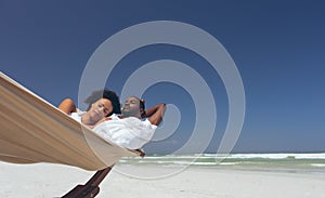 Young couple relaxing on hammock at beach