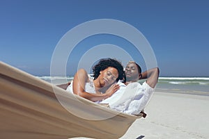 Young couple relaxing on hammock at beach