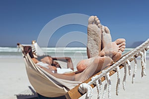 Young couple relaxing on hammock at beach