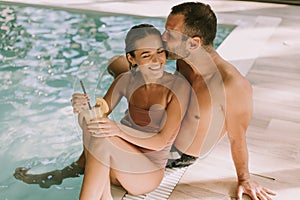 Young couple relaxing by the indoor swimming pool