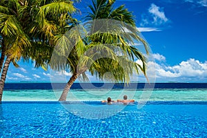 Young couple relaxing in infinity pool