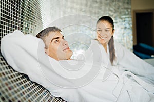 Young couple relaxing inside spa bath room.Romantic newlyweds enjoying honeymoon vacation day doing body treatment in luxury