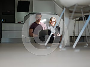 Couple using tablet and laptop computers