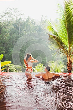 Young couple relaxing luxury private infinity pool