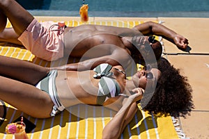 Young couple relaxing near swimming pool on a sunny day