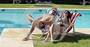 Young couple relaxing at a resort swimming pool