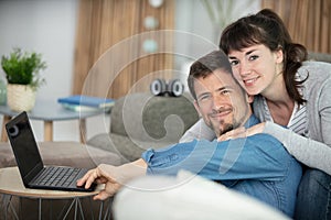 young couple relaxing sitting on sofa using computer