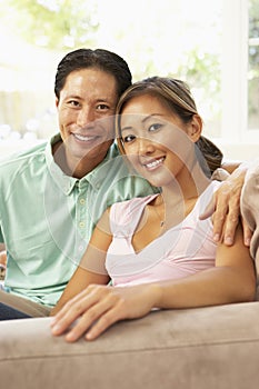 Young Couple Relaxing On Sofa At Home