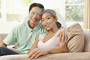 Young Couple Relaxing On Sofa At Home