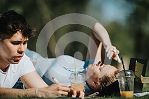 Young couple relaxing and studying together in the park