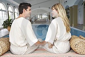 Young Couple Relaxing By Swimming Pool