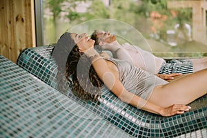 Young couple relaxing on the tepidarium bed in the spa