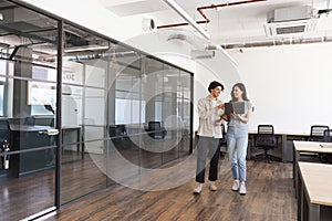 Young couple renting work space for start up business having informal meeting in open plan office