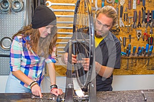 Young couple repairing bicycle in the workshop