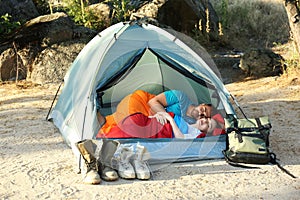 Young couple resting in sleeping bags inside