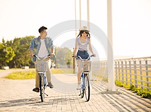 Young couple riding on bicycle in city park