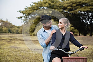 Young couple riding a bicycle in the park