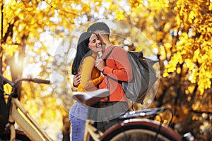 Young couple riding a bicycle on a sunny autumn day. The park is colorful