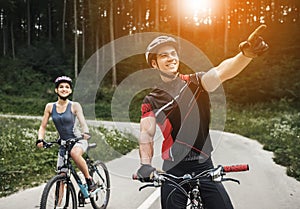 Young Couple Riding on Bicycles at Forest Road.