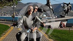 A young couple is riding a electro bike at urban park