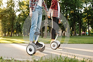 Young couple riding on gyroboard in park at sunset