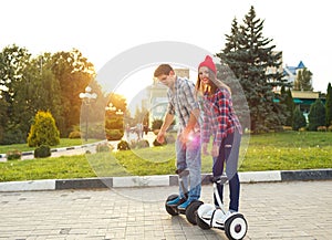 A young couple riding hoverboard - electrical scooter, personal