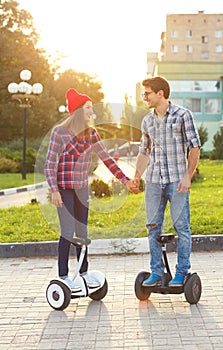 A young couple riding hoverboard - electrical scooter, personal