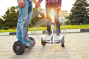 A young couple riding hoverboard - electrical scooter, personal